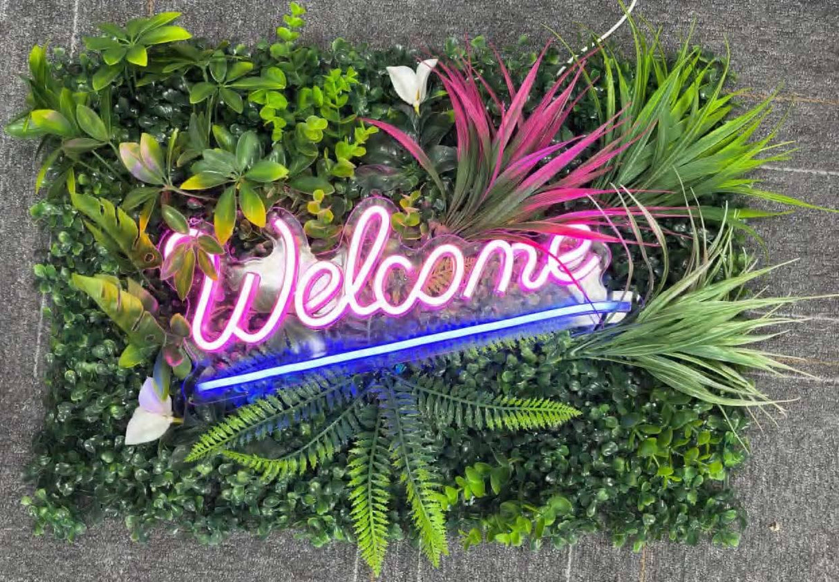 フェイクグリーンウォールとピンク・ブルーのLEDネオンサインを組み合わせたグリーンネオン看板|Welcomeデザイン